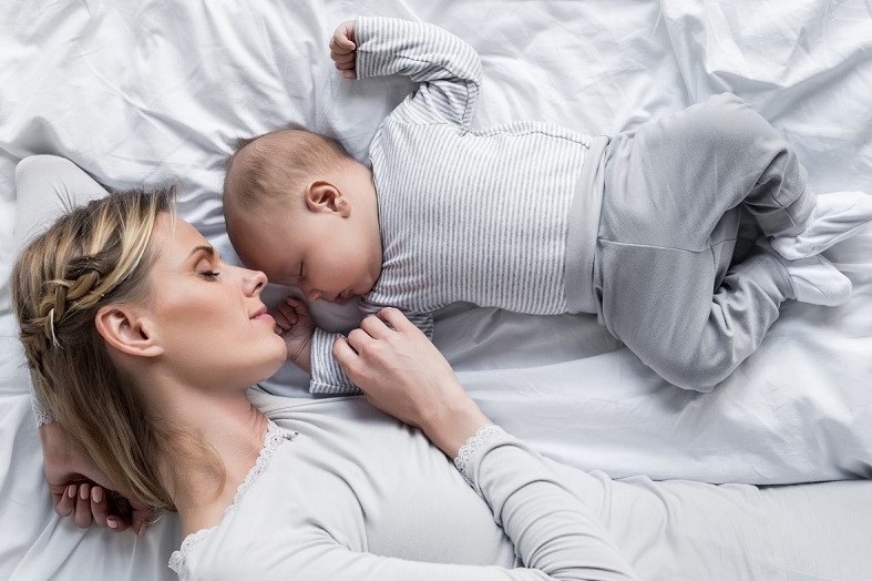 mother with baby sleeping in bed Newborn baby sleeping